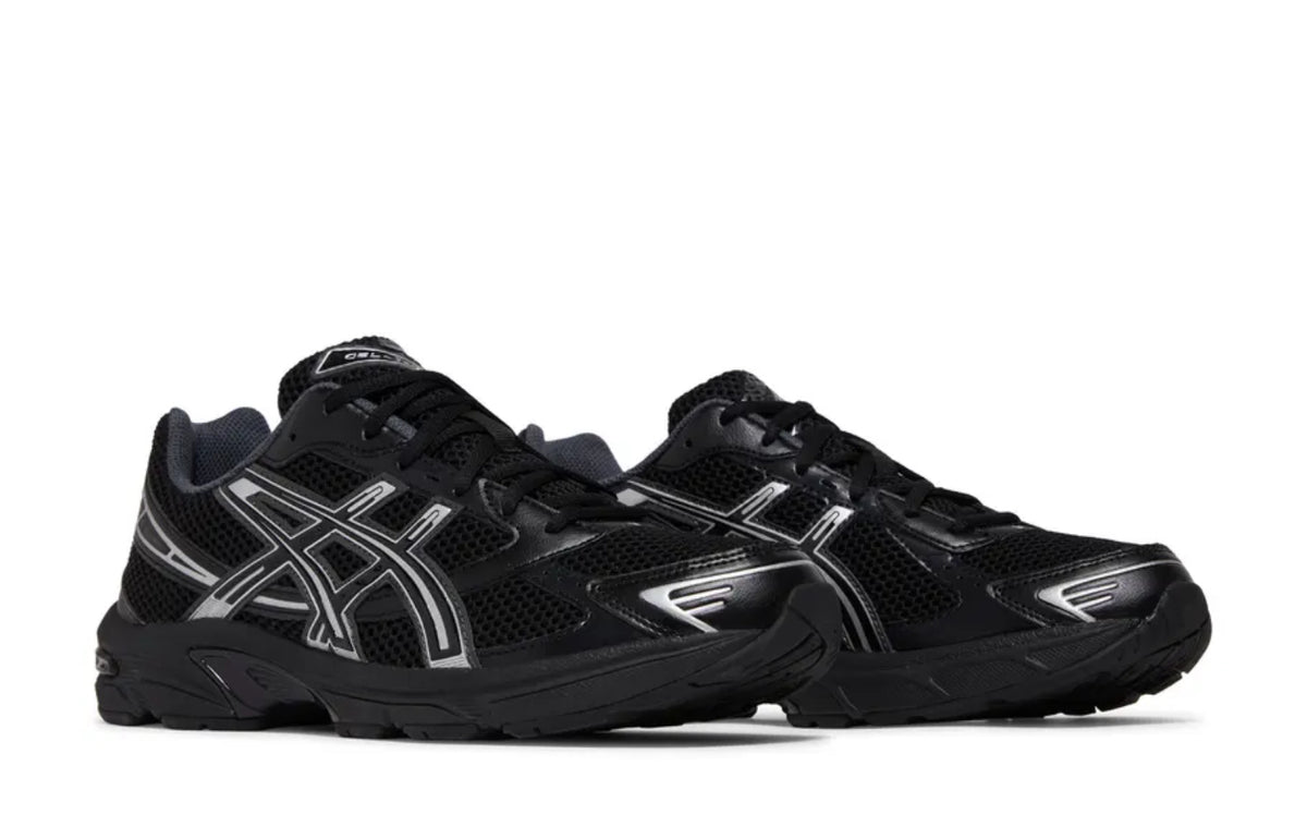 A pair of black and silver ASICS sneakers with mesh uppers, reflective detailing, and a cushioned sole for comfort and performance.