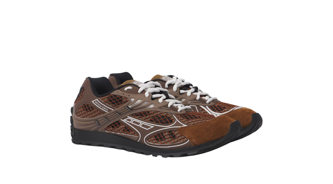 A pair of Bottega Veneta sneakers featuring a brown mesh upper, suede details, reflective accents, and white laces with a chunky sole