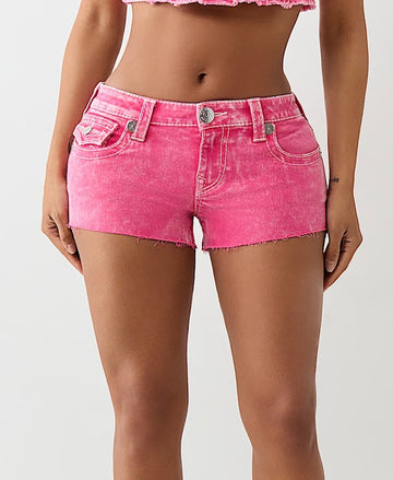 Woman wearing bright pink denim shorts with frayed hems, front button closure, and multiple pockets, shown from the front at mid-thigh.