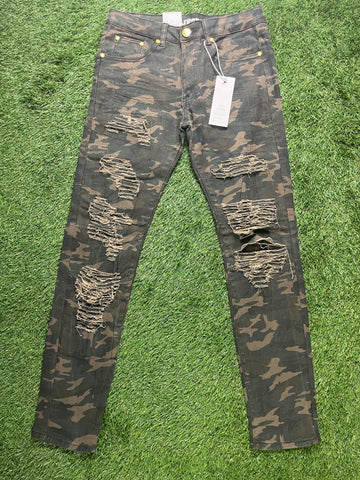 A pair of camo-patterned skinny jeans with multiple distressed rips, yellow button details, and price tags attached.