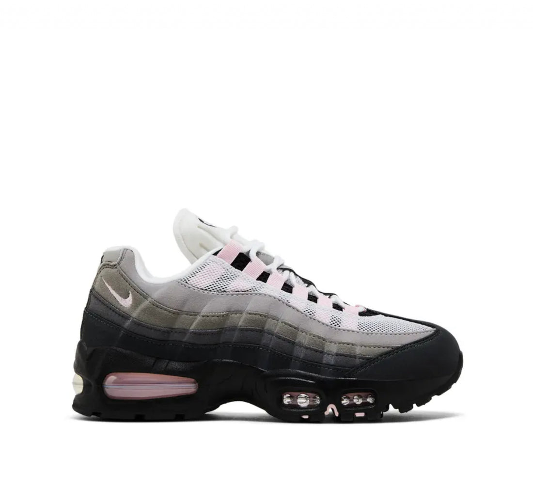 Side view of Nike Air Max 95 sneaker with gradient gray shades, black sole, pink air unit, and white mesh upper, on white background.