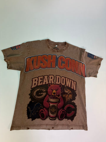 A vintage faded brown short-sleeve t-shirt with a distressed graphic reading 'KUSH CONN' and 'BEARDOWN' featuring a cartoon bear holding a coffee cup.